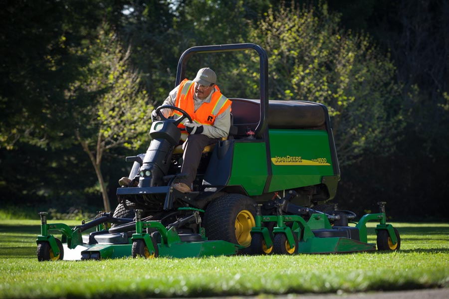 Rubicon crew member mowing turf on a large riding mower