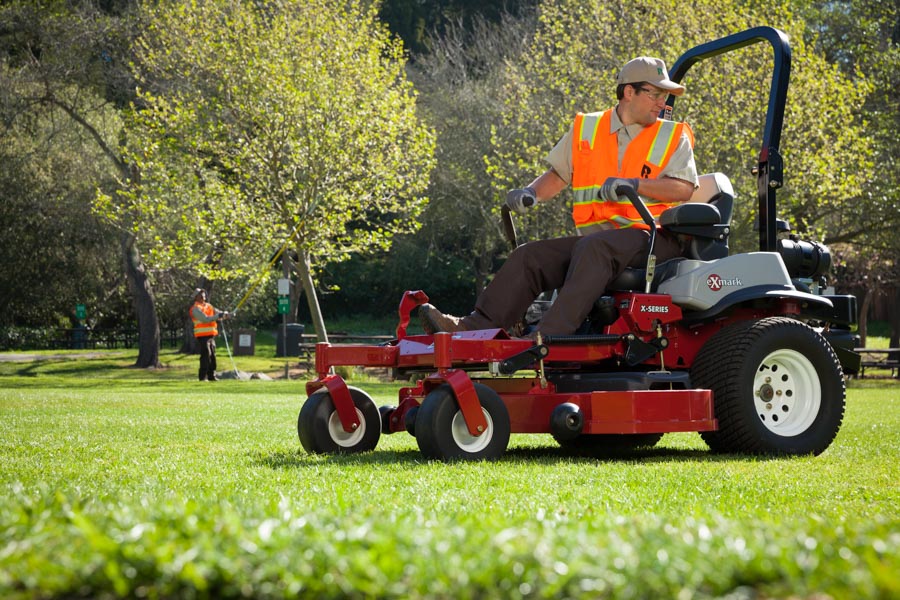 Rubicon crew member mowing a park lawn on a riding mower