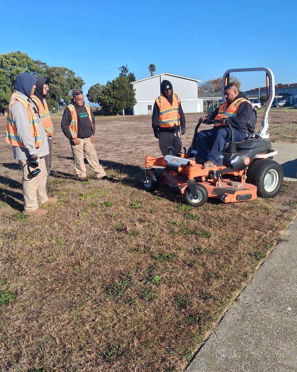 Treasure Island trainees learning to operate a riding mower with a Rubicon instructor