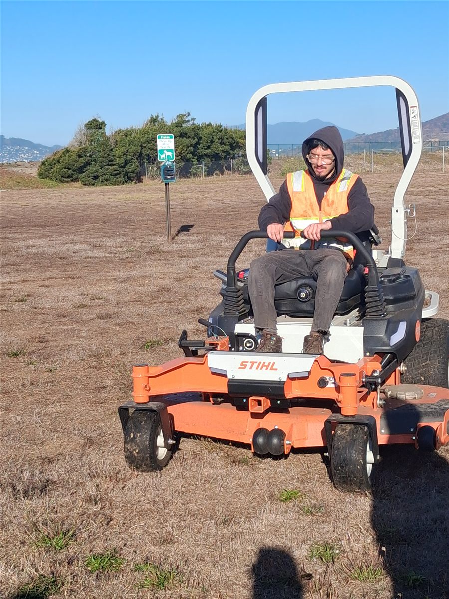 A Rubicon trainee learning to operate a riding mower on Treasure Island